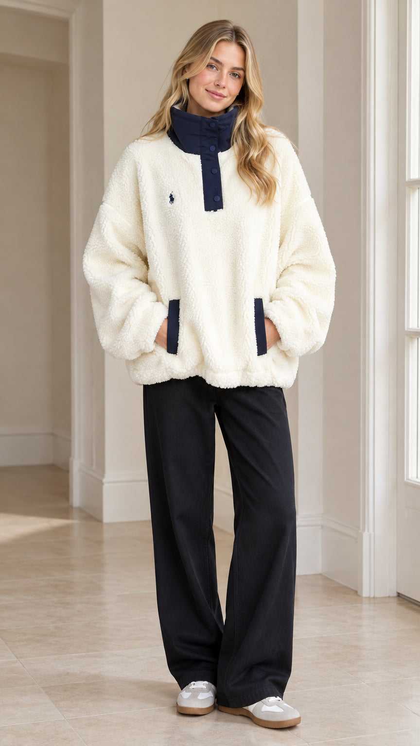 Front full-length view of woman wearing Cream sherpa fleece snap-neck pullover with black pants