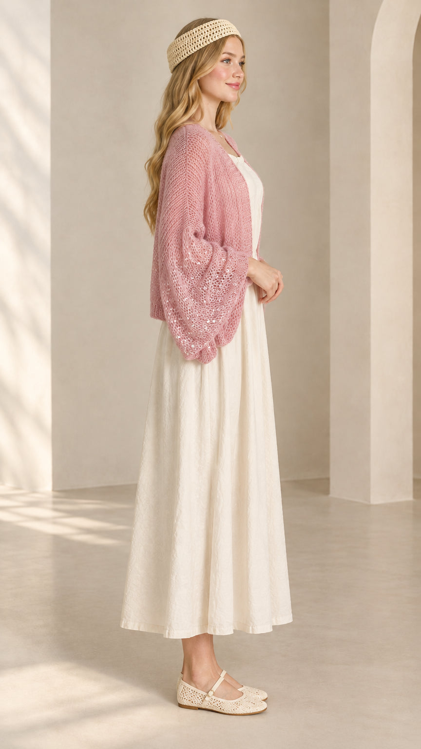 Side angle view of pink open-knit bolero cardigan with balloon sleeves