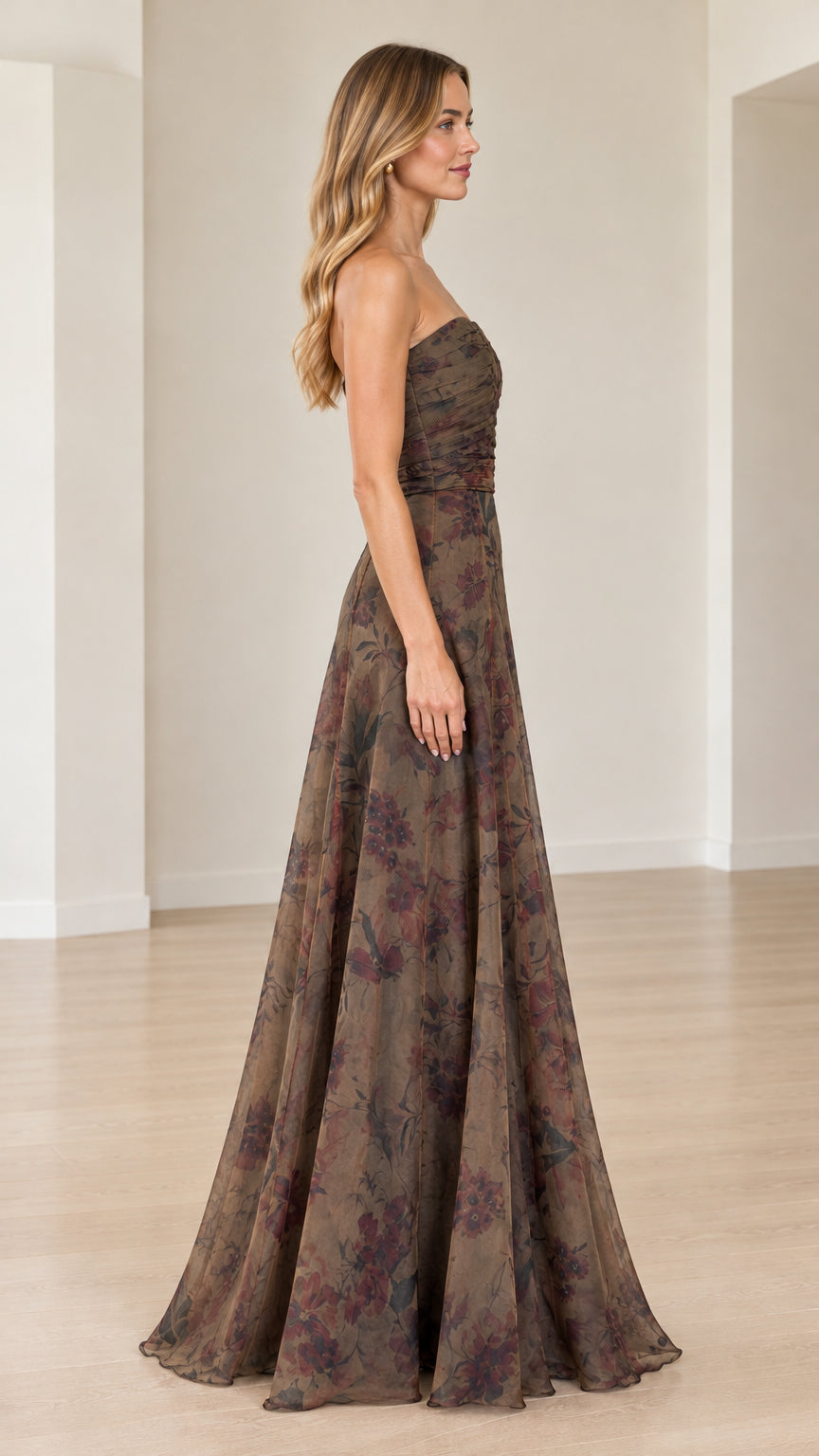 Side profile of model wearing mocha strapless floral maxi gown