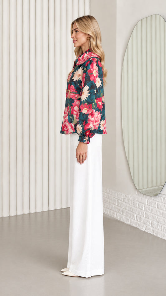Side profile view of dark teal floral collared jacket paired with white trousers