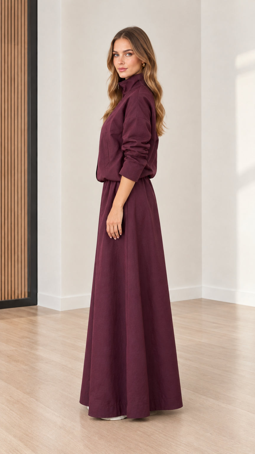 Side view of model wearing Burgundy high neck maxi dress with elastic waist