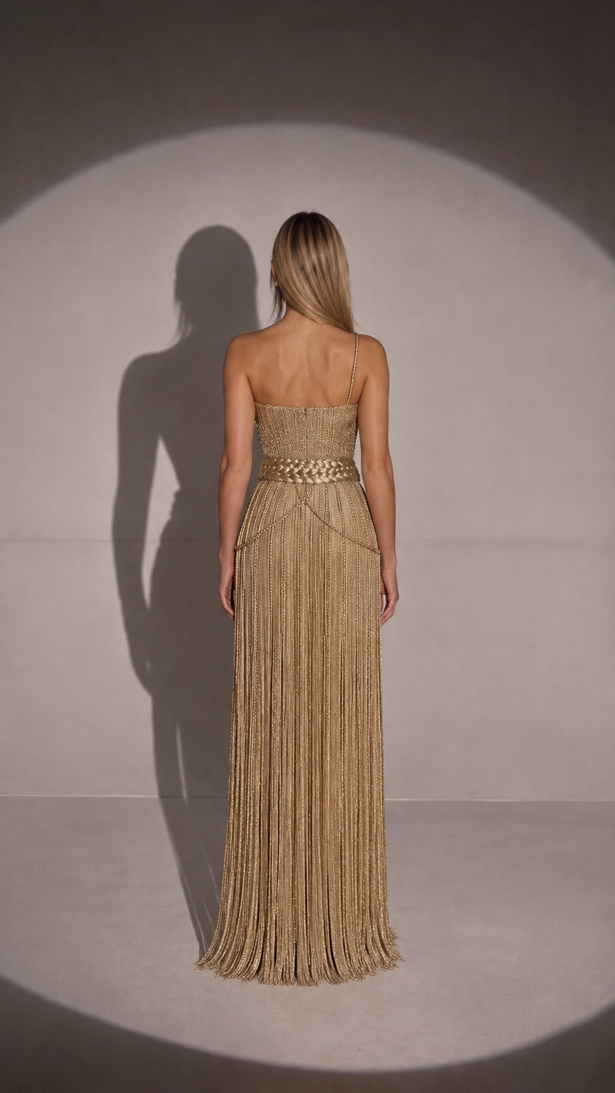 Back view of gold fringe maxi gown showing straight backline and braided waist