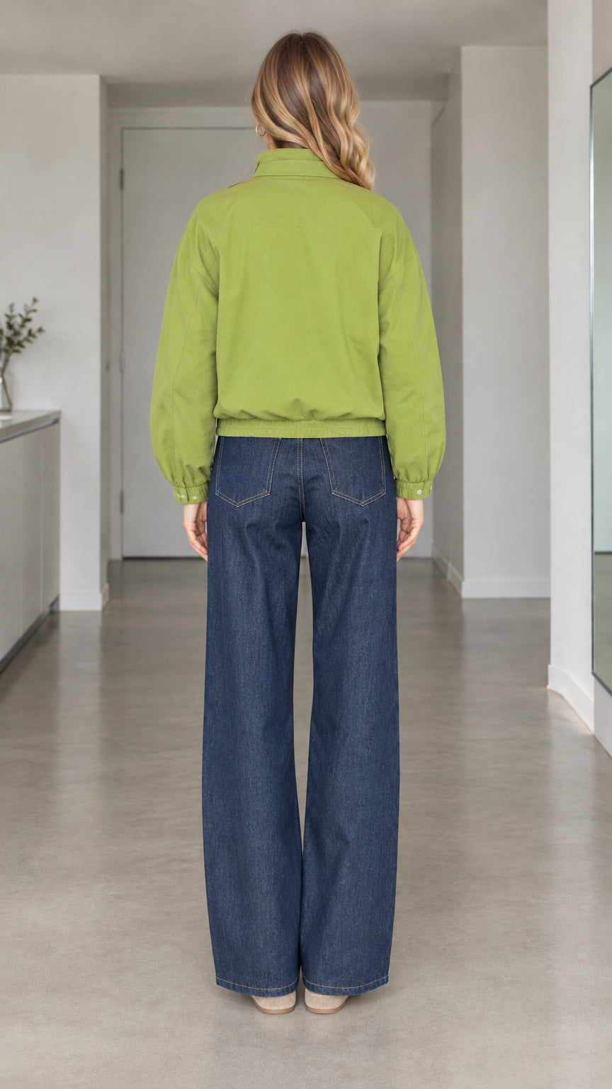 Rear view of model showing gathered elastic hem and shoulders of green bomber jacket