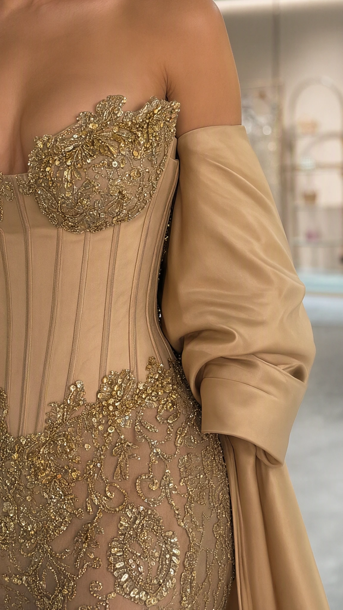 Close-up of champagne corset bodice with intricate gold embroidery and boning details