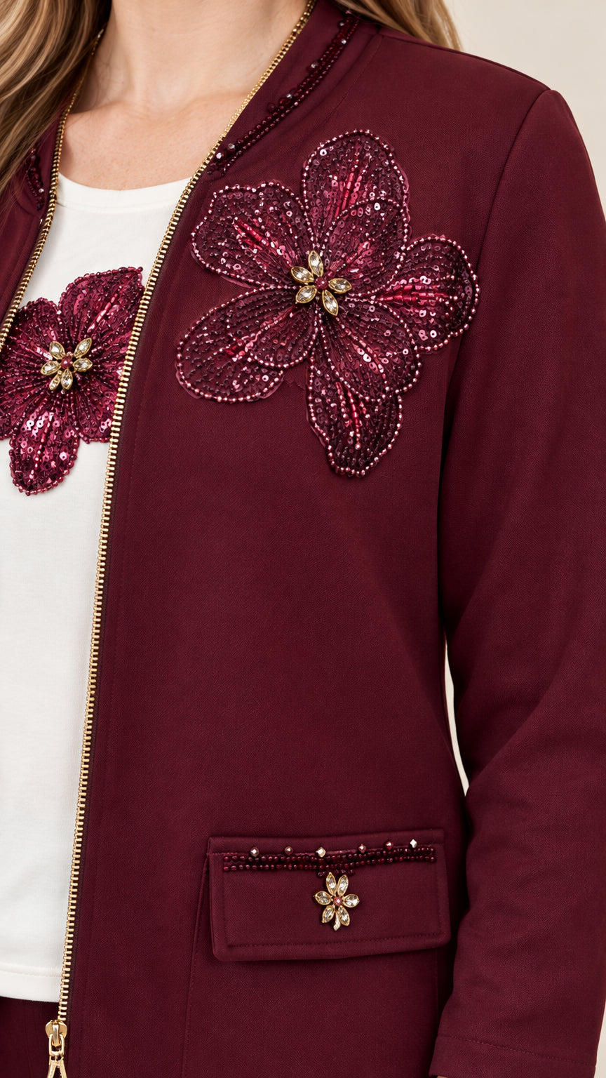 Close-up detail of burgundy jacket with sequined floral appliqué and embellished pocket flap