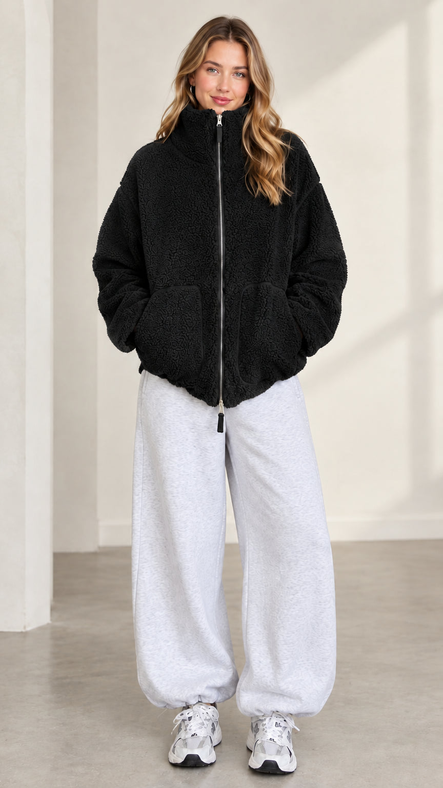 Front view of model wearing black zip-up teddy fleece jacket