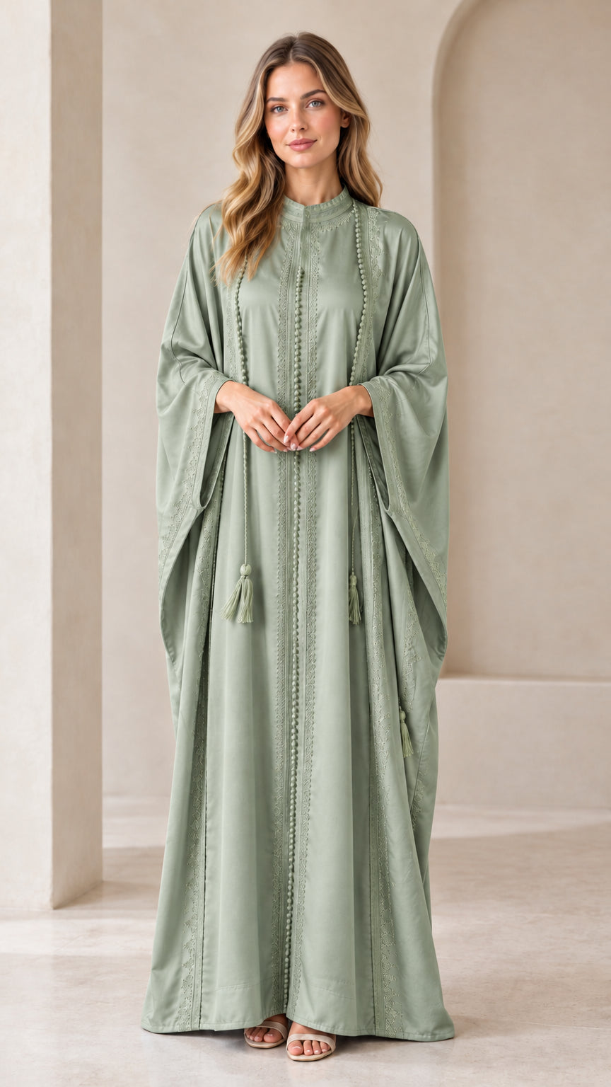 Front view of woman wearing Sage Green embroidered batwing kaftan maxi dress with tassels
