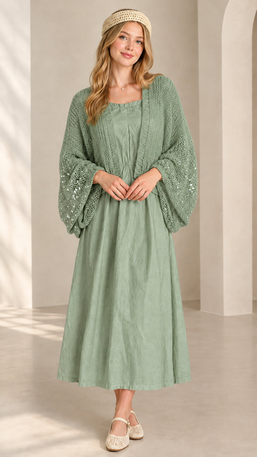 Front view of sage green sequin open-knit cropped shrug over matching green dress