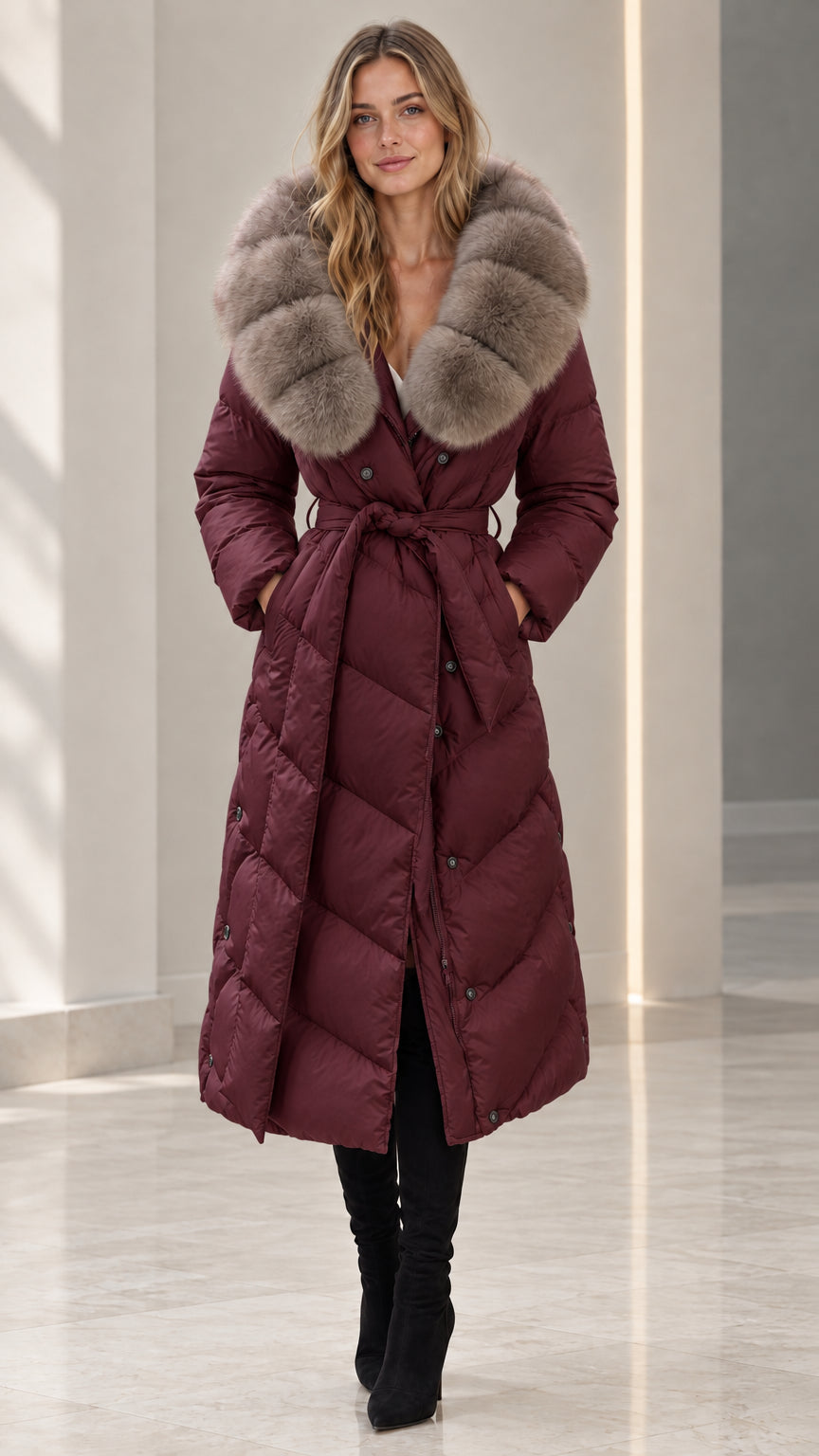 Front full-length view of woman wearing burgundy wine belted maxi puffer coat with plush fur collar
