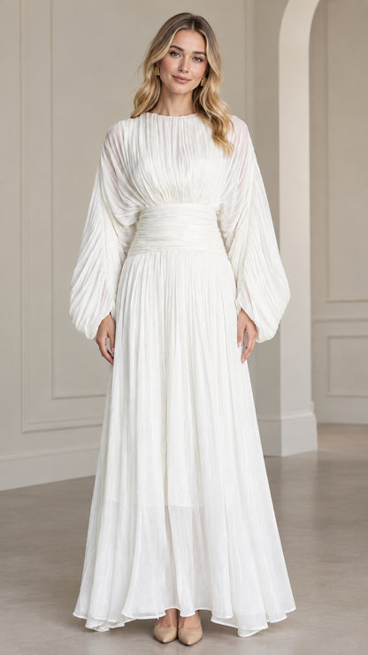 Front full-length view of woman wearing white pleated long sleeve maxi dress