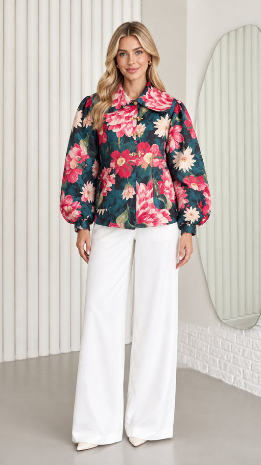 Front full-length view of model wearing dark teal floral jacket with balloon sleeves and white wide-leg trousers
