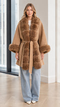 Front view of model wearing Camel faux fur trim belted cape coat with wide-leg jeans