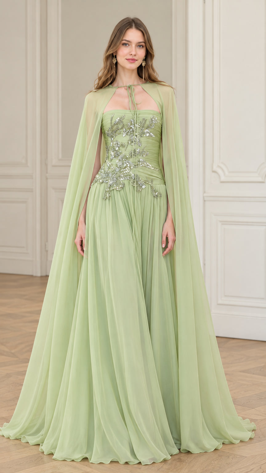 Front view of model wearing sage green strapless evening gown with matching sheer cape