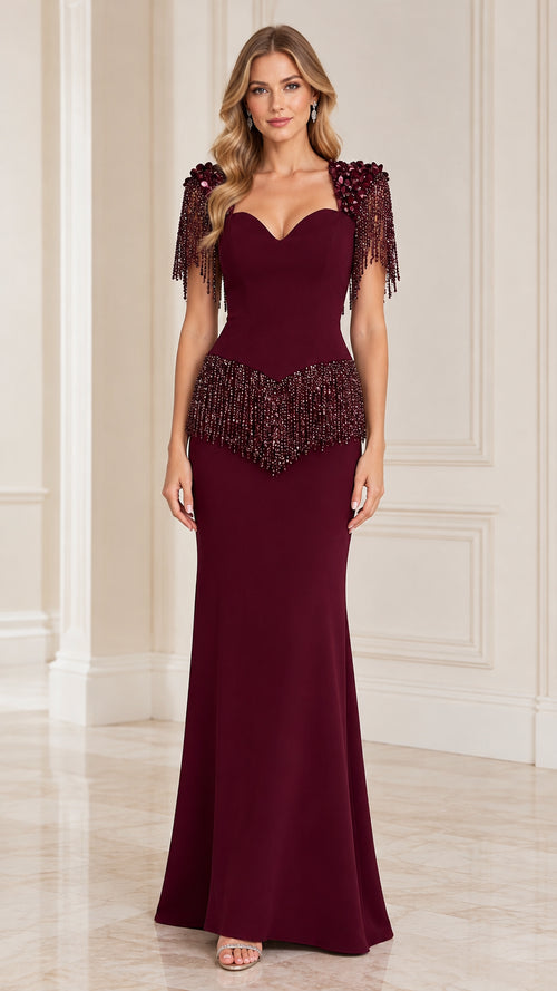 Front view of model wearing burgundy sweetheart evening gown with beaded fringe shoulders and waist