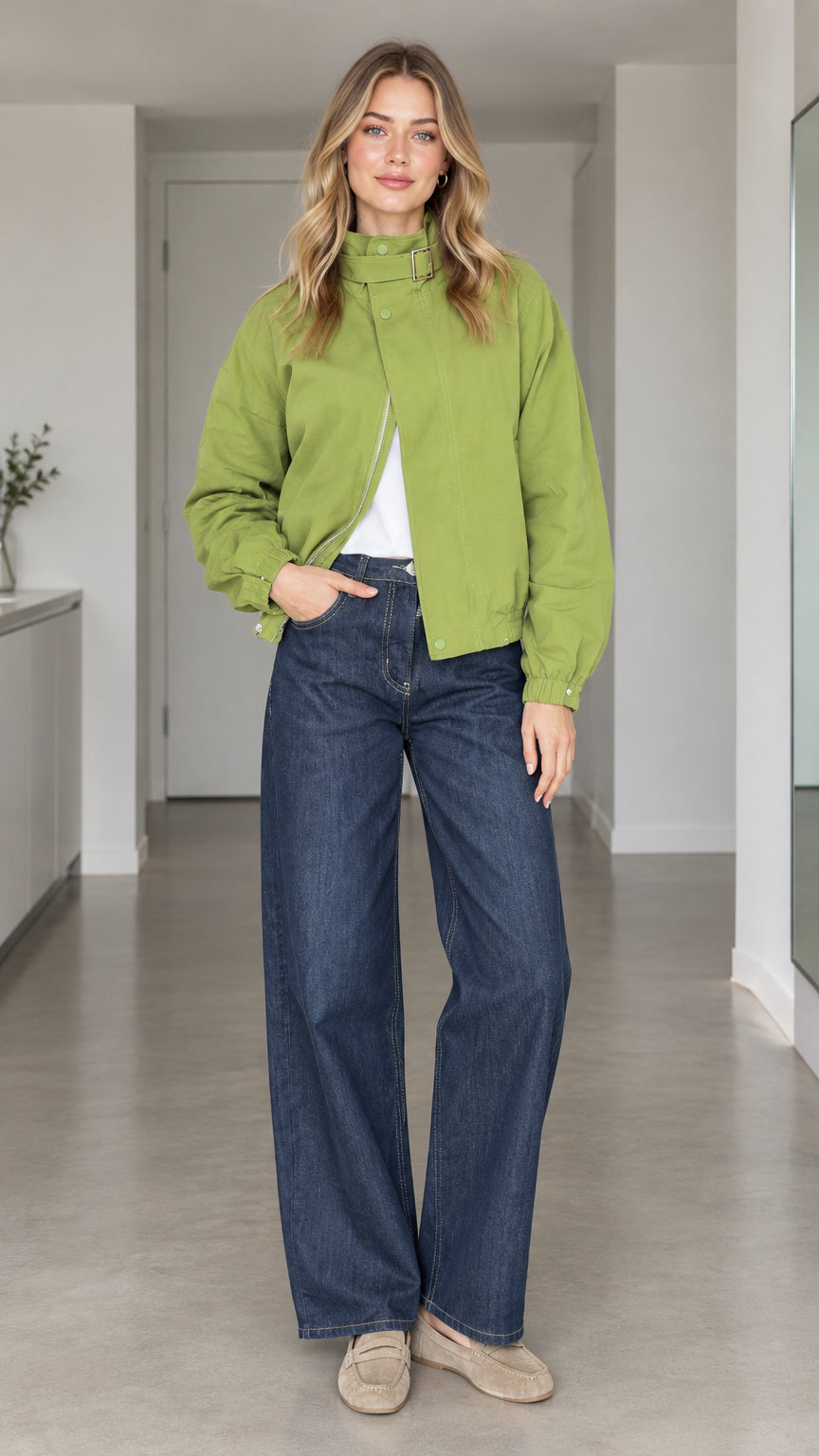 Front view of model wearing a green high-collar buckle bomber jacket paired with wide-leg jeans
