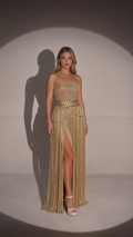 Front full view of woman wearing gold one-shoulder fringe maxi gown