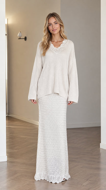 Front view of model wearing cream crochet V-neck sweater and matching knit maxi skirt set