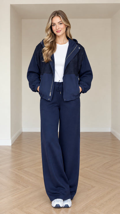 Model wearing navy blue women's hooded zip-up jacket and wide-leg pants set front view