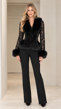 Front full-length view of model wearing black lace jacket with black faux fur trim and flare trousers