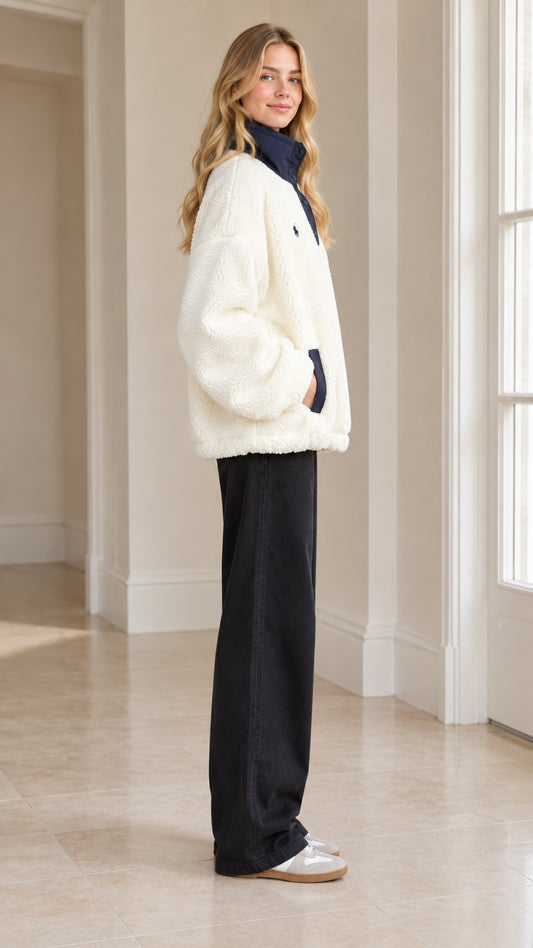 Side full-length view of woman modeling Cream sherpa fleece pullover with navy collar trim