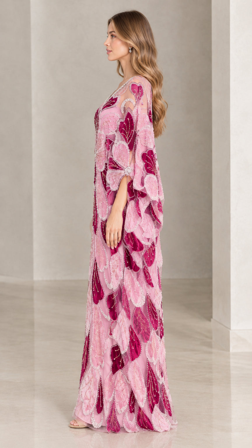 Side profile view of woman wearing pink embroidered flowing caftan gown