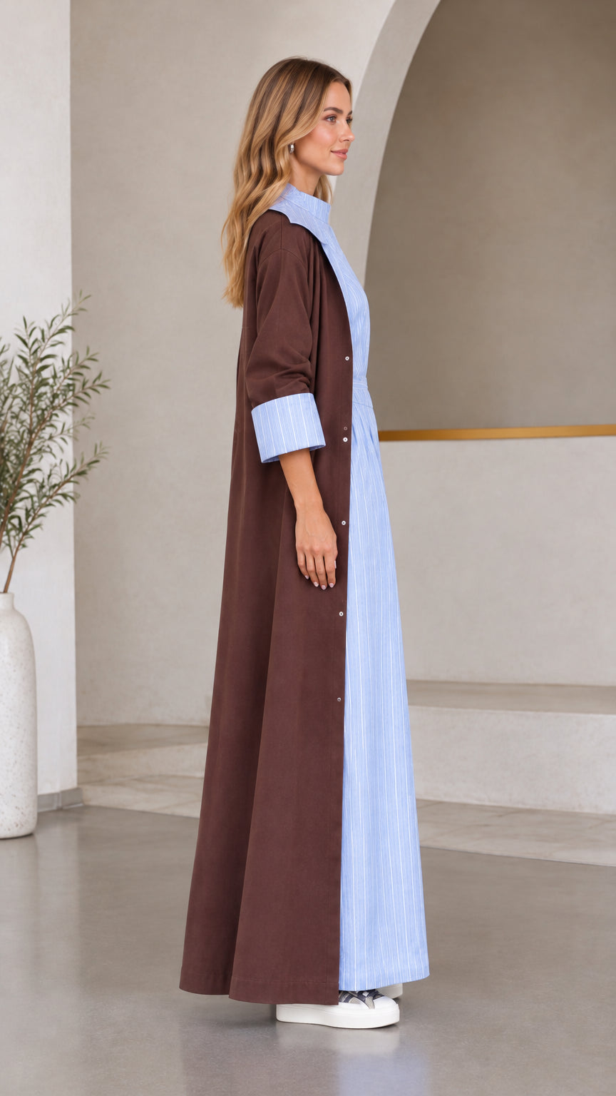 Side profile view of women's brown maxi coat and light blue striped set