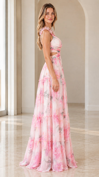 Side view of woman posing in pink floral sleeveless tiered maxi gown
