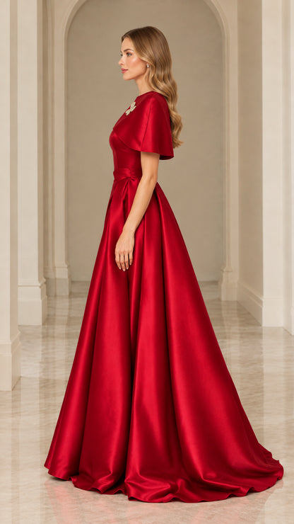 Side profile view of red satin floor-length formal gown with cape sleeve overlay