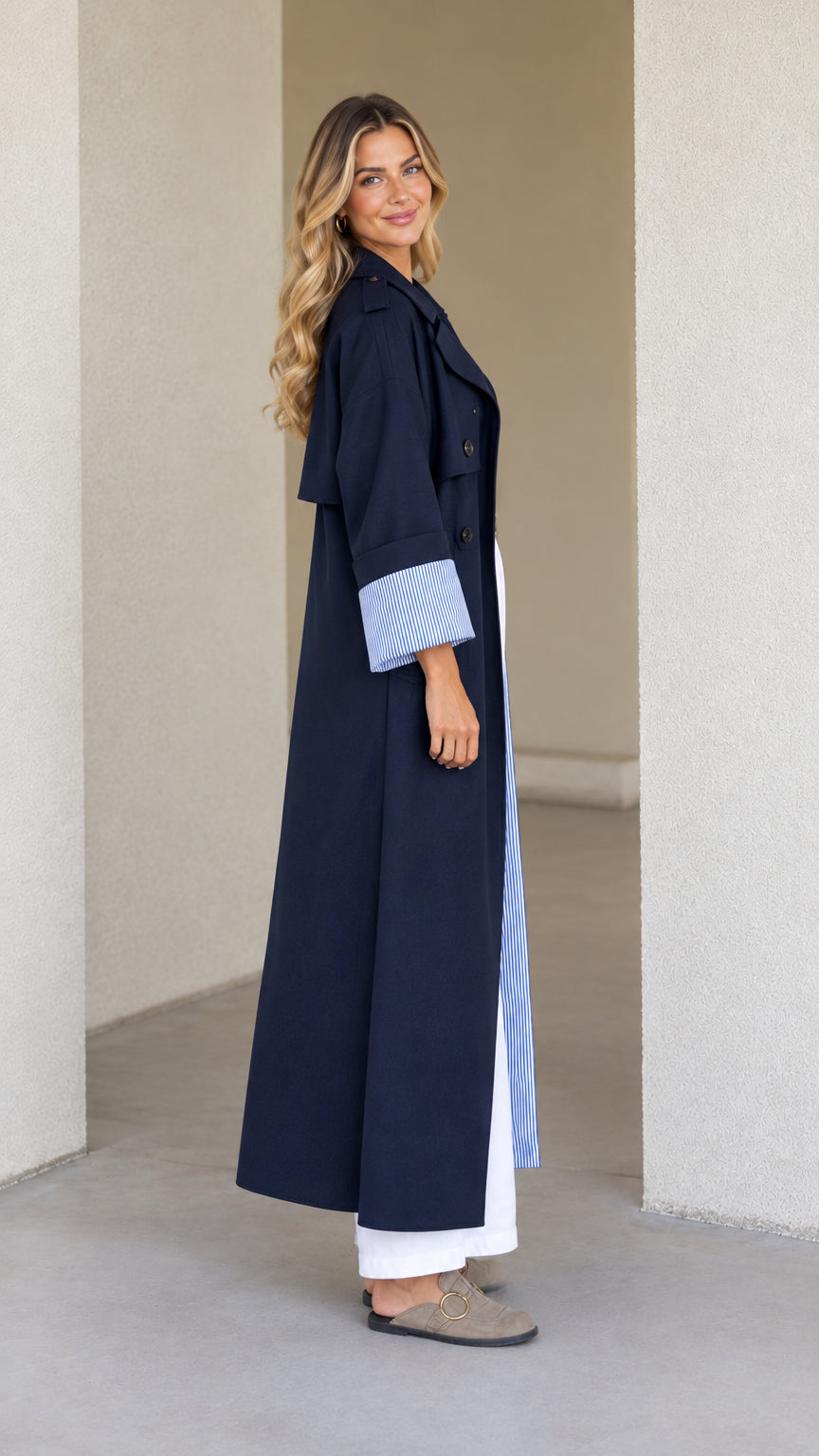 Side profile of model in full-length Navy Blue duster coat showcasing drape and sleeve detail