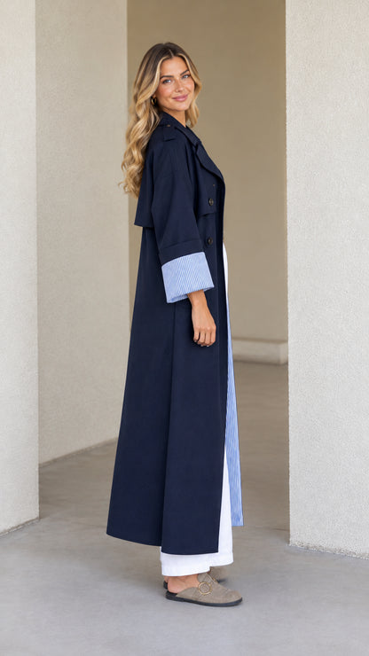 Side profile of model in full-length Navy Blue duster coat showcasing drape and sleeve detail