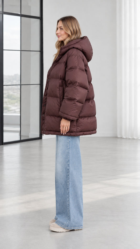 Side profile view of model in chocolate brown quilted hooded puffer jacket