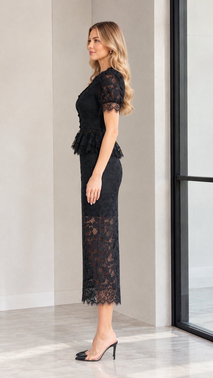 Side profile of model in black peplum lace midi dress