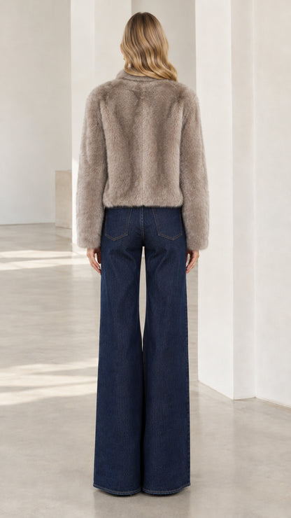Back view of model wearing taupe waist-length faux fur coat