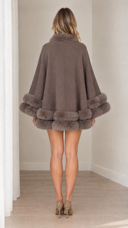 Back view of model showcasing the fluid drape of taupe faux fur cape