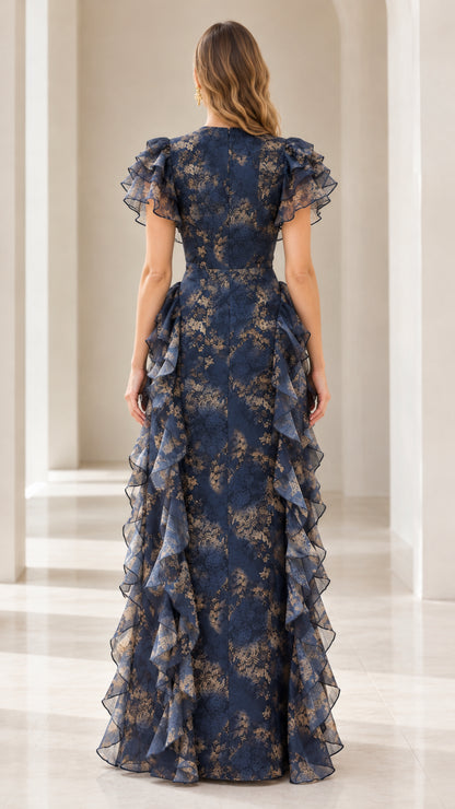Back view of model wearing floor-length Navy Blue floral gown with flutter sleeves