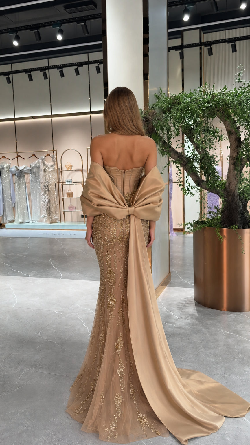 Champagne evening gown back view highlighting lace-up corset and bow cape train