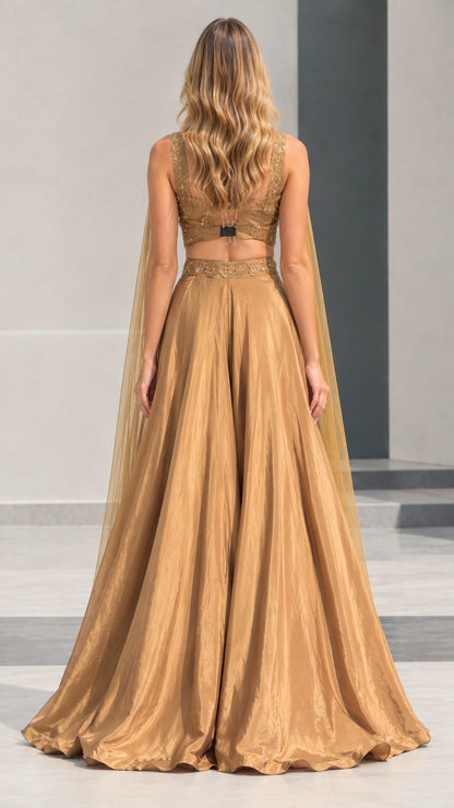 Back view of gold cape evening gown set showing open back and skirt drape