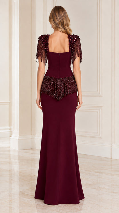 Back view of model in burgundy floor-length gown showing square back and fringe detail