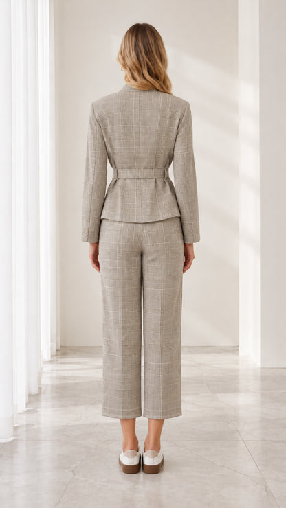 Back view of model wearing tailored grey plaid belted blazer and trousers