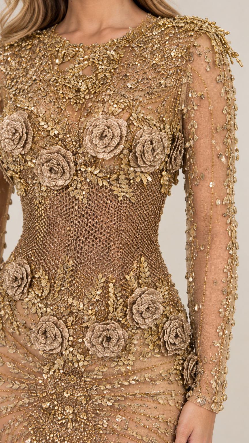 Close-up detail of gold bodice featuring 3D floral rosettes, intricate beading, and mesh texture