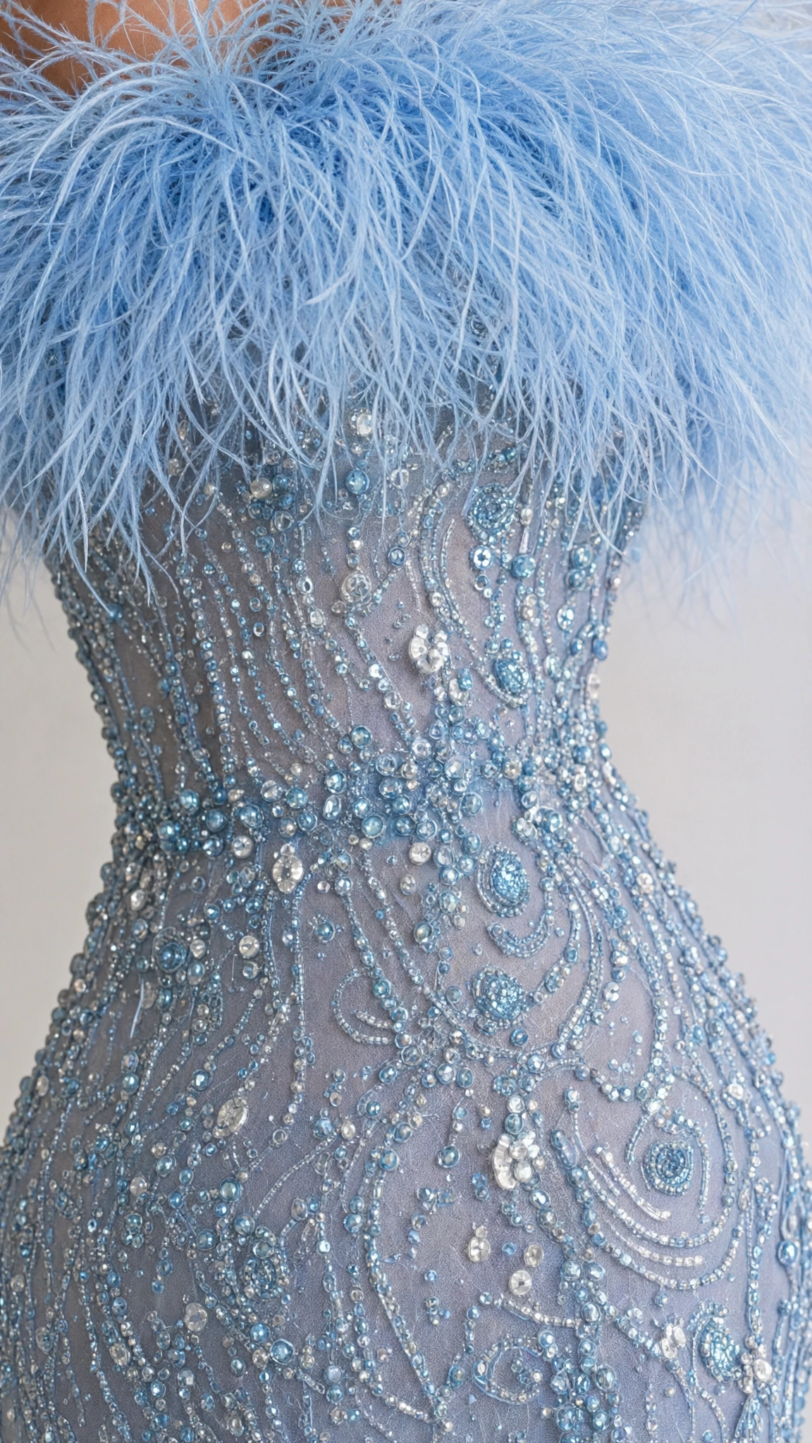 Close-up detail of plush sky blue feather neckline and intricate sequin beadwork on bodice