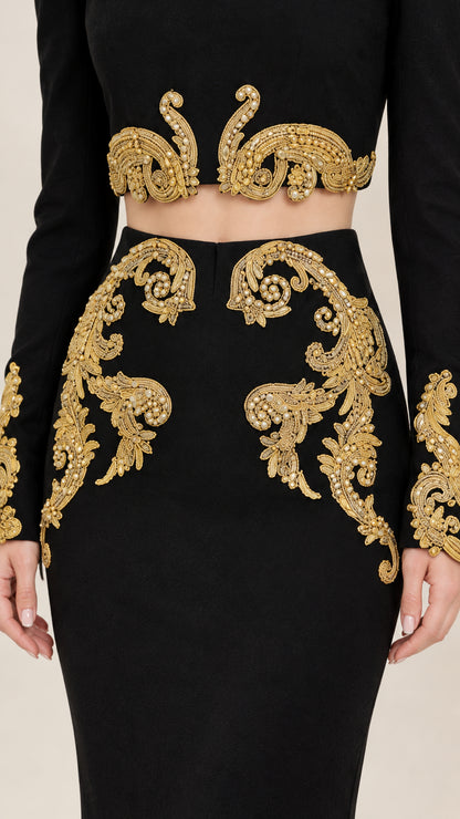 Close-up detail of ornate gold baroque embroidery on crop top hem and skirt waist