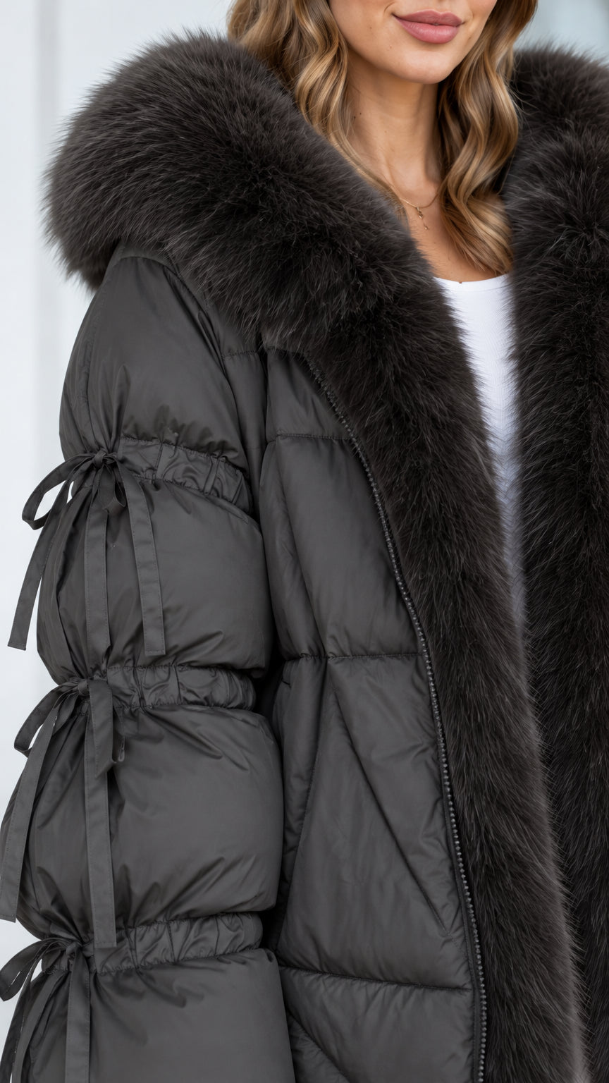 Close-up detail of plush faux fur collar and bow-tie ruched sleeves on charcoal puffer jacket