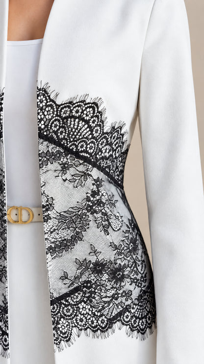 Close-up detail of white tailored fabric and delicate black floral eyelash lace trim