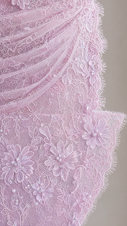 Close-up detail of textured floral lace fabric with bead embellishment and eyelash trim