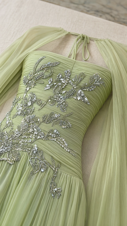 Close-up detail of silver floral beadwork and pleating on sage green gown bodice