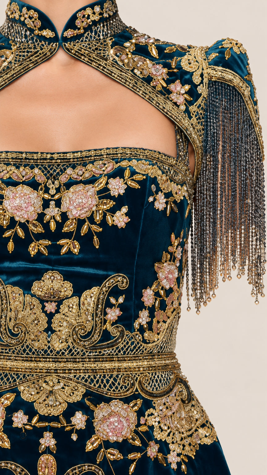 Close up of detailed gold floral embroidery and tassel fringe on velvet fabric