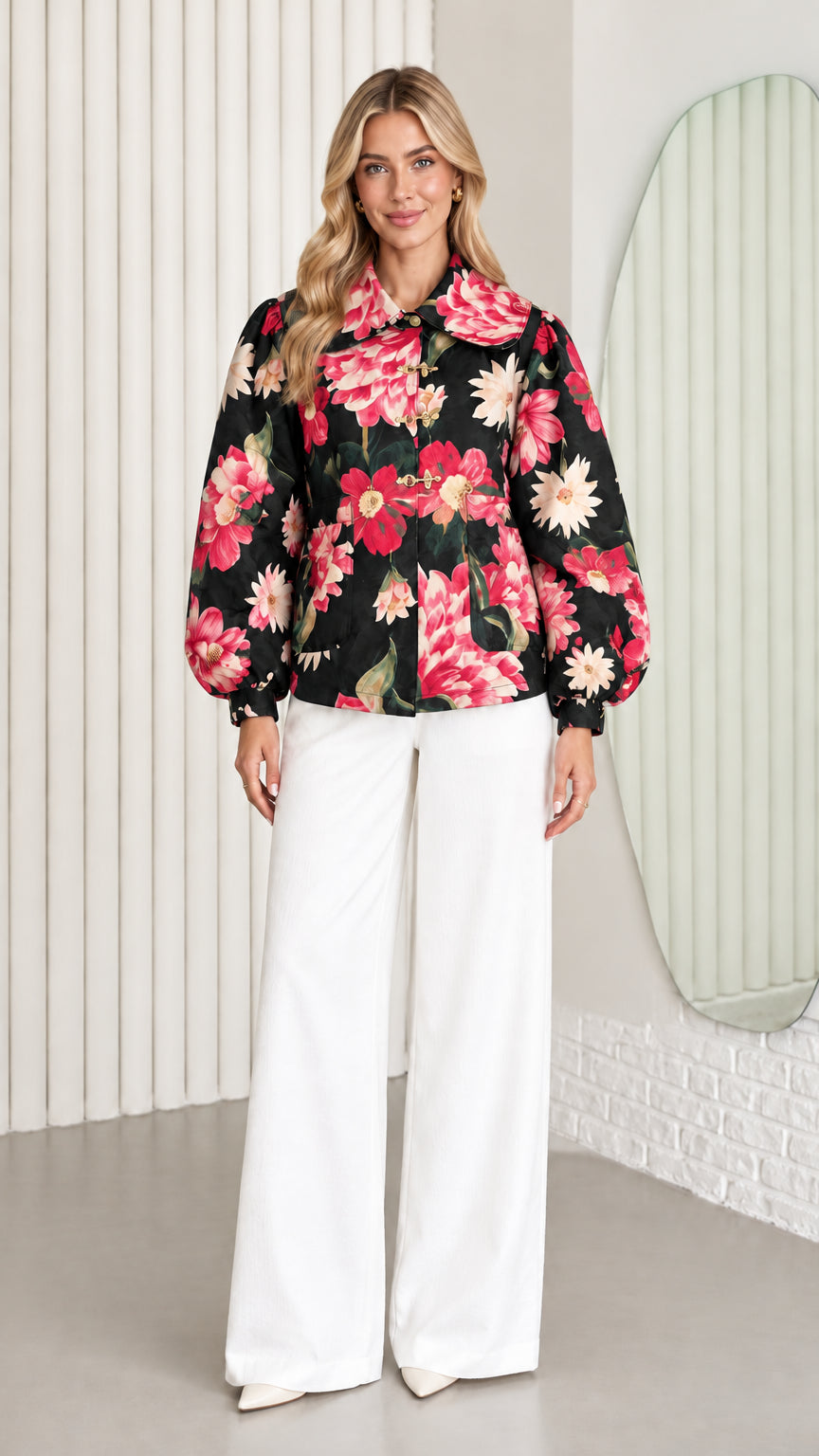 Front view of model wearing black floral balloon sleeve jacket with white wide-leg trousers