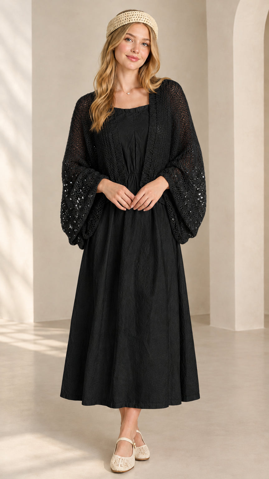 Front view of black sequin open-knit bolero shrug paired with matching black dress