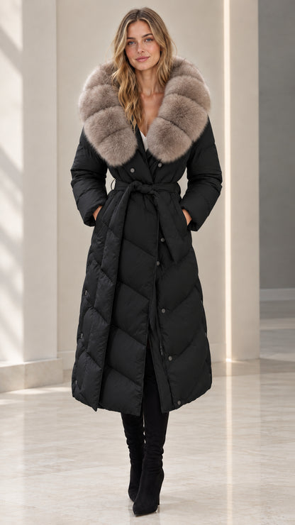 Front full-length view of woman wearing black belted maxi puffer coat with plush fur collar